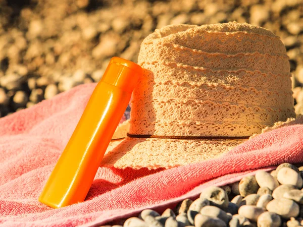 Zonnehoed en zonnebrandcrème op Stone Beach — Stockfoto