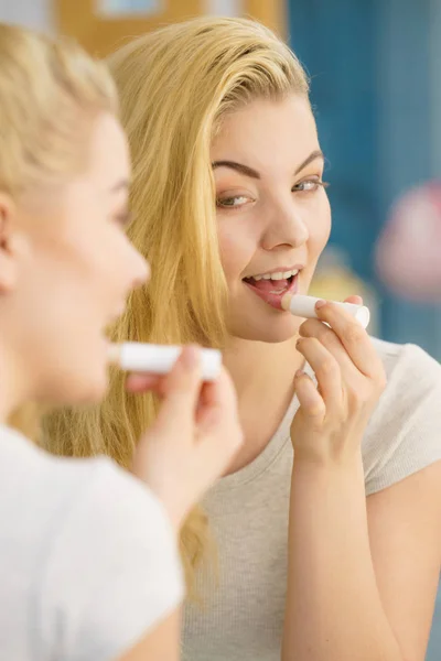 Mujer en baño aplicando bálsamo labial —  Fotos de Stock