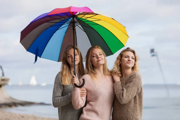 Tres mujeres bajo paraguas colorido — Foto de Stock