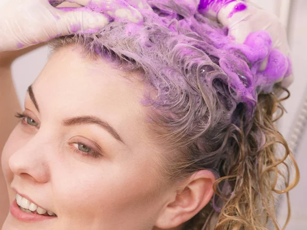Женщина намазывает шампунь тонером на волосы — стоковое фото