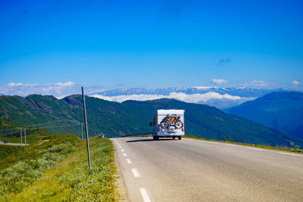Автомобиль-кемпер с велосипедами на дороге
