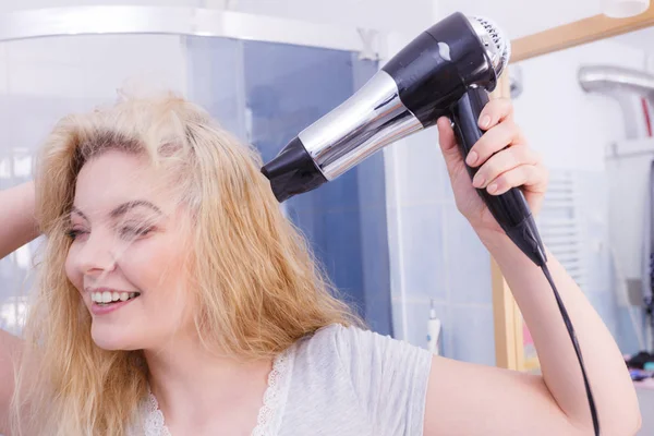 Frau trocknet Haare im Badezimmer — Stockfoto