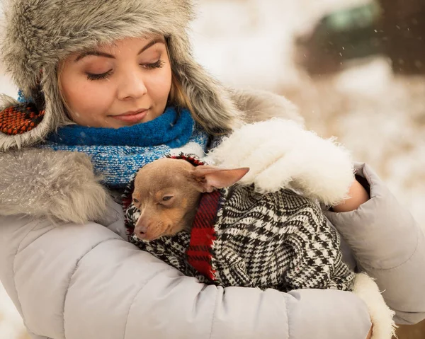 Mujer abrazo calentando su pequeño perro en invierno —  Fotos de Stock