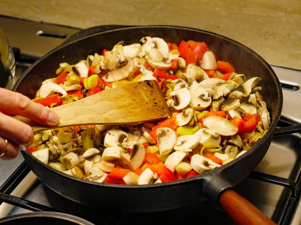 Ajouter des champignons à la casserole de légumes . — Photo