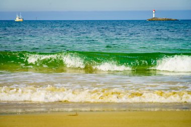 Ufukta deniz feneri ile deniz manzarası kum plaj