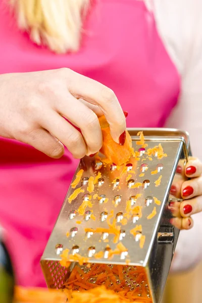 Donna che grattugia la carota sulla grattugia di metallo — Foto Stock