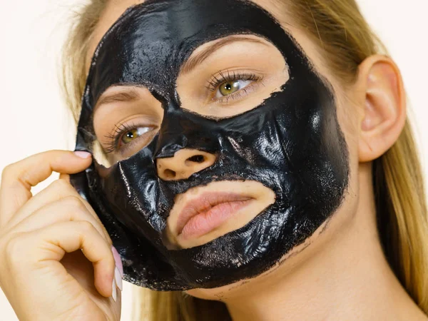 Girl removes black mask from face — Stock Photo, Image