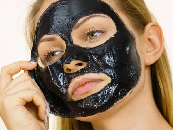 Mädchen entfernt schwarze Maske aus Gesicht — Stockfoto