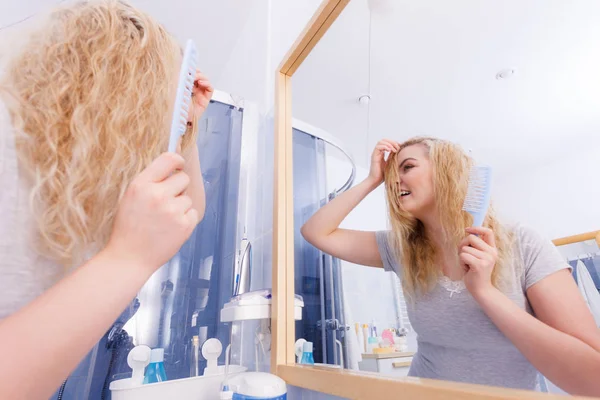 Mulher escovando seu cabelo loiro molhado — Fotografia de Stock