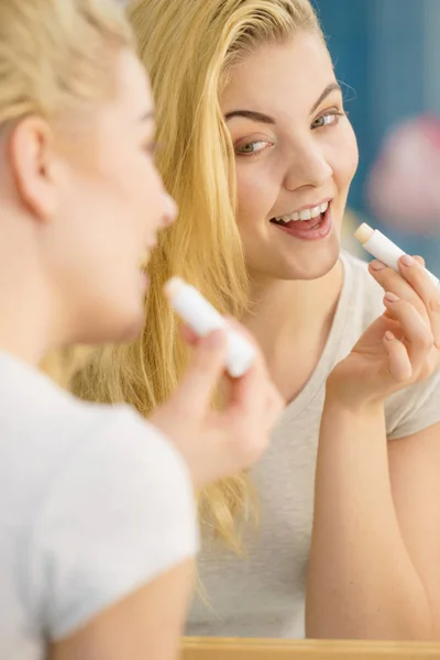 Mujer en baño aplicando bálsamo labial —  Fotos de Stock