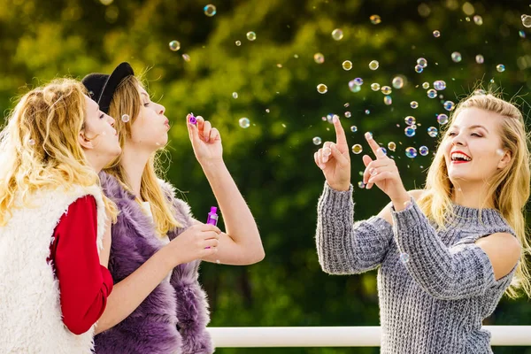 Mulheres soprando bolhas de sabão, se divertindo — Fotografia de Stock