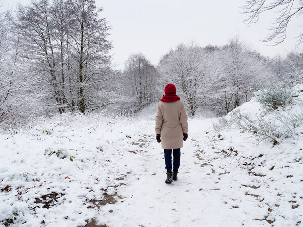 Woman walk in winter snow forest.