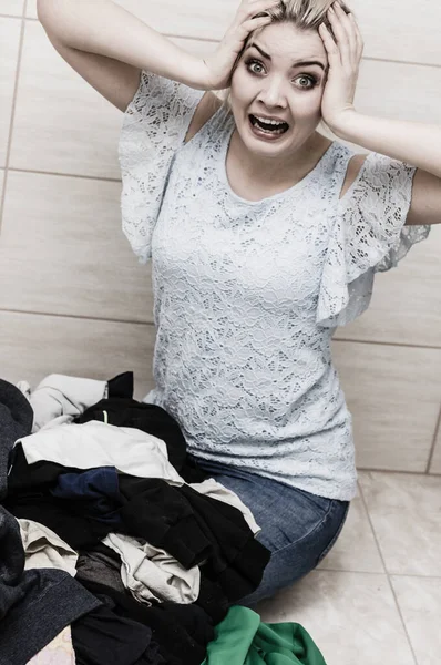 Unhappy girl sorting dirty clothes laundry. — Stock Photo, Image