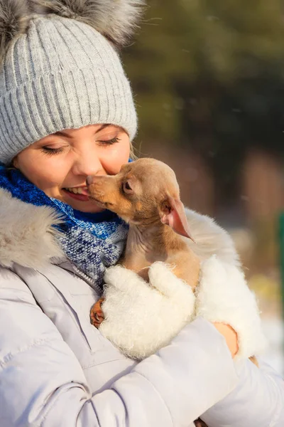 Mulher brincando com cão durante o inverno — Fotografia de Stock