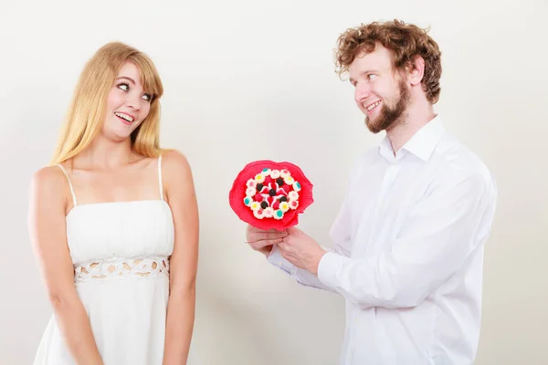 Coppia felice con fiori di mazzo di caramelle. Amore. . — Foto Stock