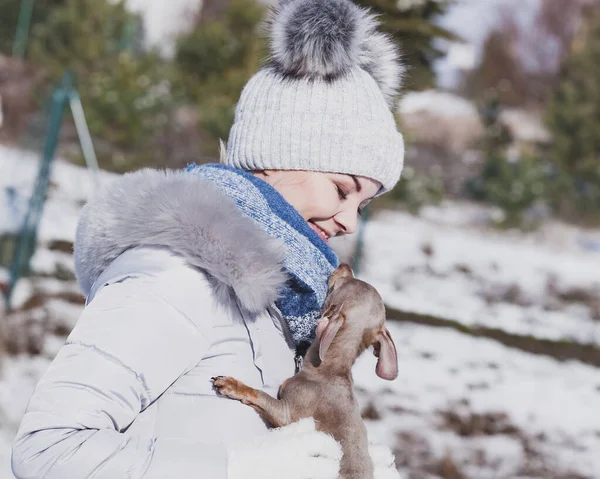 Mulher brincando com cão durante o inverno — Fotografia de Stock