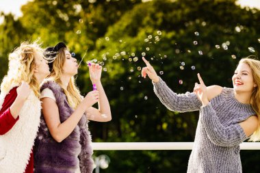 Sabun kabarcıkları üfleyen kadınlar, eğleniyorlar