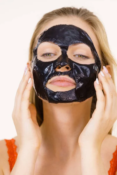 Девушка в черной маске с высохшей кожурой на лице — стоковое фото