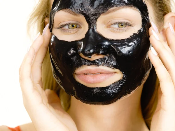 Menina com descascamento seco máscara preta no rosto — Fotografia de Stock