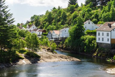 Nehir kıyısındaki Norveç beyaz evleri. Güzel köy, İskandinavya Avrupa