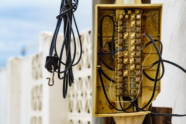 Dışarıdaki duvarda karmakarışık haldeki kablolu elektrik kabloları.