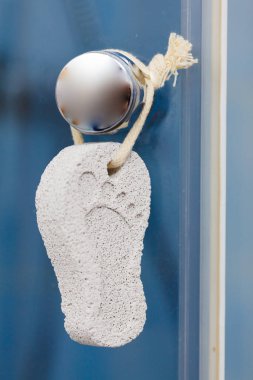 Ayak bakımı. Pedikür aksesuarı, banyoda ayak izi olan taş süngerler.