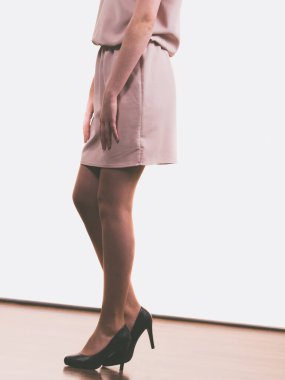 Elbise, etek ve siyah şık topuklu giyen tanınmamış bir kadın..