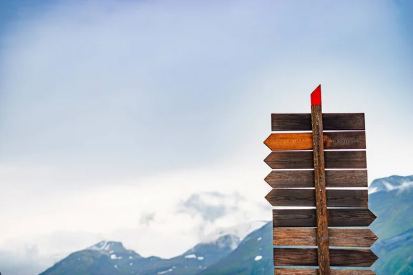 Tourism vacation and travel. Wooden signpost in norwegian mountains. Rainy cloudy weather.