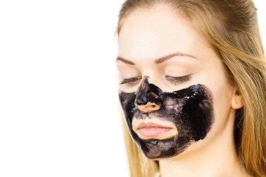 Yüzüne karbonhidrat maskesi takan genç bir kadın. Genç kız yağlı cildiyle ilgileniyor, gözenekleri temizliyor. Spa tedavisi. Cilt bakımı.