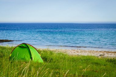 Yazın deniz kıyısında çadır. Okyanus kıyısında kamp yapmak. Lofoten takımadaları Norveç. Tatil ve seyahat.