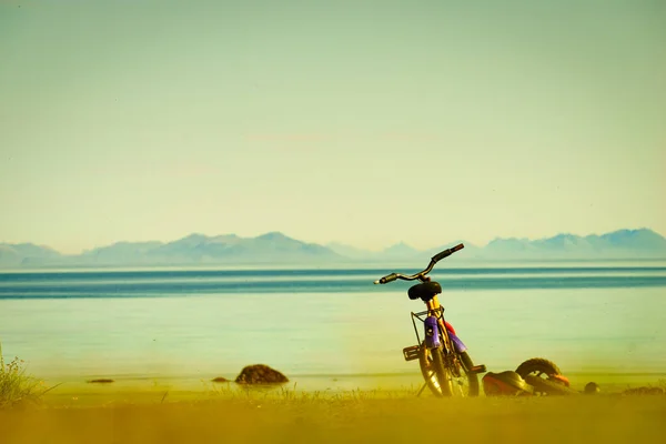 Child bike with safety helmet parked on beach seashore in summer. Lofoten archipelago Norway. Holidays and adventure.