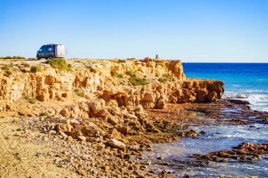 Kamp aracı, güney İspanya 'da Akdeniz kıyısında, deniz uçurumunda eğlence aracı. Deniz kenarında kamp yapmak. Tatiller ve karavanda seyahat.