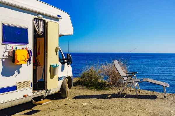 Wild camping on sea shore. Camper car rv with clothes hanging to dry. Holidays with motor home.