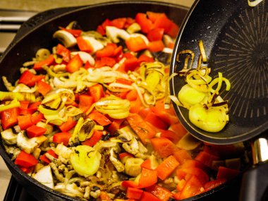 Lezzetli yemek hazırlıyorum. Karışık sebzelerle sıcak tavaya taze kızarmış soğan ekliyorum..