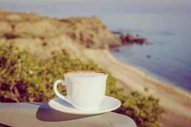 Kahve fincanı, deniz kenarındaki arka planda. Kamp, tatil, yaşam tarzı konsepti.