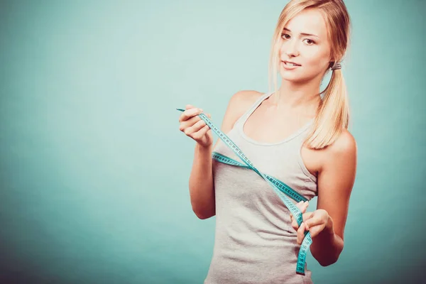 여자는 파란색 가슴의 크기를 측정하는 줄자를 사용하여 운동복을 여자에게 맞는다 — 스톡 사진