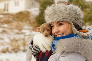 Genç bir kadın soğuk kış gününde en iyi arkadaşını sıcak battaniye eşarbına sardı. Hayvan koruma programı. Evlat edinme kavramı