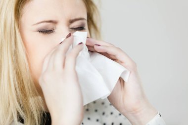 Hastalık, mevsimsel virüs problemi konsepti. Kadın hasta, grip olmuş, dokuya hapşırıyor.