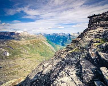 Dalsnbba bölgesinden Geirangerfjord ile panoramik dağlar manzarası. Geiranger Skywalk dağdaki platformu uzaktan görüyor. Norveç.