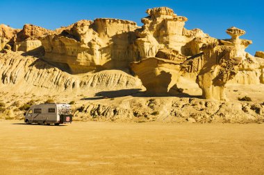 Aşınmış sarı kumtaşı oluşumlarındaki park yerinde kamp arabası, Büyülü Şehir Bolnuevo, Murcia İspanya. Turist eğlencesi.