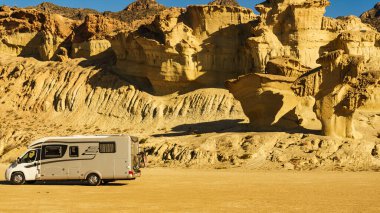 Aşınmış sarı kumtaşı oluşumlarındaki park yerinde kamp arabası, Büyülü Şehir Bolnuevo, Murcia İspanya. Turist eğlencesi.