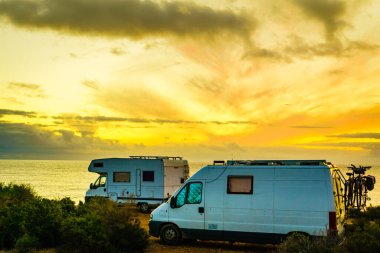 Kampçılar, İspanya 'nın Murcia bölgesindeki Akdeniz kıyısı Costa Calida' da gün doğumunda karavan kullanıyorlar. Doğa plajında kamp yapmak. Tatil ve karavanda yolculuk.