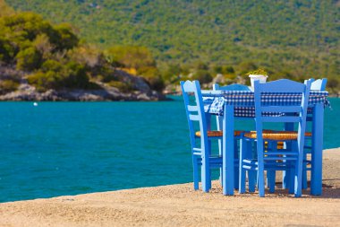 Deniz kenarındaki mavi masa ve sandalyeler deniz kıyısında Yunanistan 'da açık bir kafe restoranı açıyor. Yaz tatili.