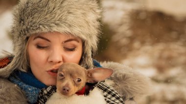 Genç bir kadın soğuk kış gününde en iyi arkadaşını sıcak battaniye eşarbına sardı. Hayvan koruma programı. Evlat edinme kavramı