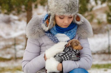 Genç üzgün kadın soğuk kış gününde en iyi arkadaşını sıcak battaniye eşarbına sardı. Hayvan koruma programı. Evlat edinme kavramı
