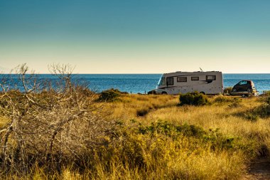Kamp aracı, İspanya 'da deniz kıyısında eğlence aracı. Doğa plajında kamp yapmak. Tatillerde ve karavanda seyahat ederken.