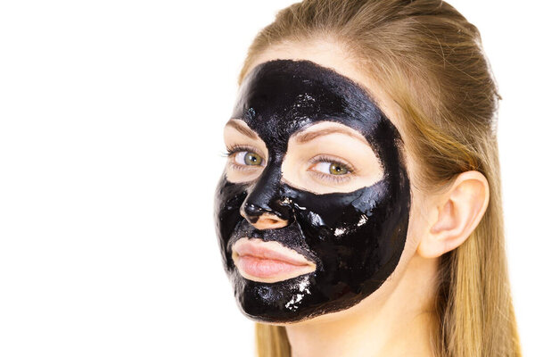 Young woman with cosmetic on face, carbo detox black peel off mask. Spa treatment. Skincare.