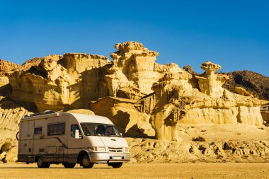 Aşınmış sarı kumtaşı oluşumlarındaki park yerinde kamp arabası, Büyülü Şehir Bolnuevo, Murcia İspanya. Turist eğlencesi.