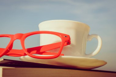 Tatillerde kitap okumak. Kahve fincanı ve açık havada kitap. Dinlenme dinlenme tatili kavramı.