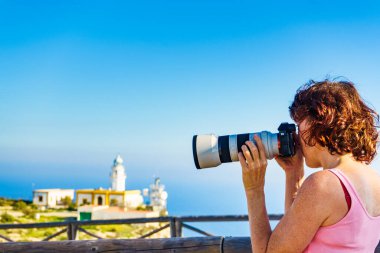 Kameralı kadın turist Mesa Roldán deniz fenerinden fotoğraf çekiyor. Cabo de Gata Nijar Doğal Parkı, Endülüs İspanya.